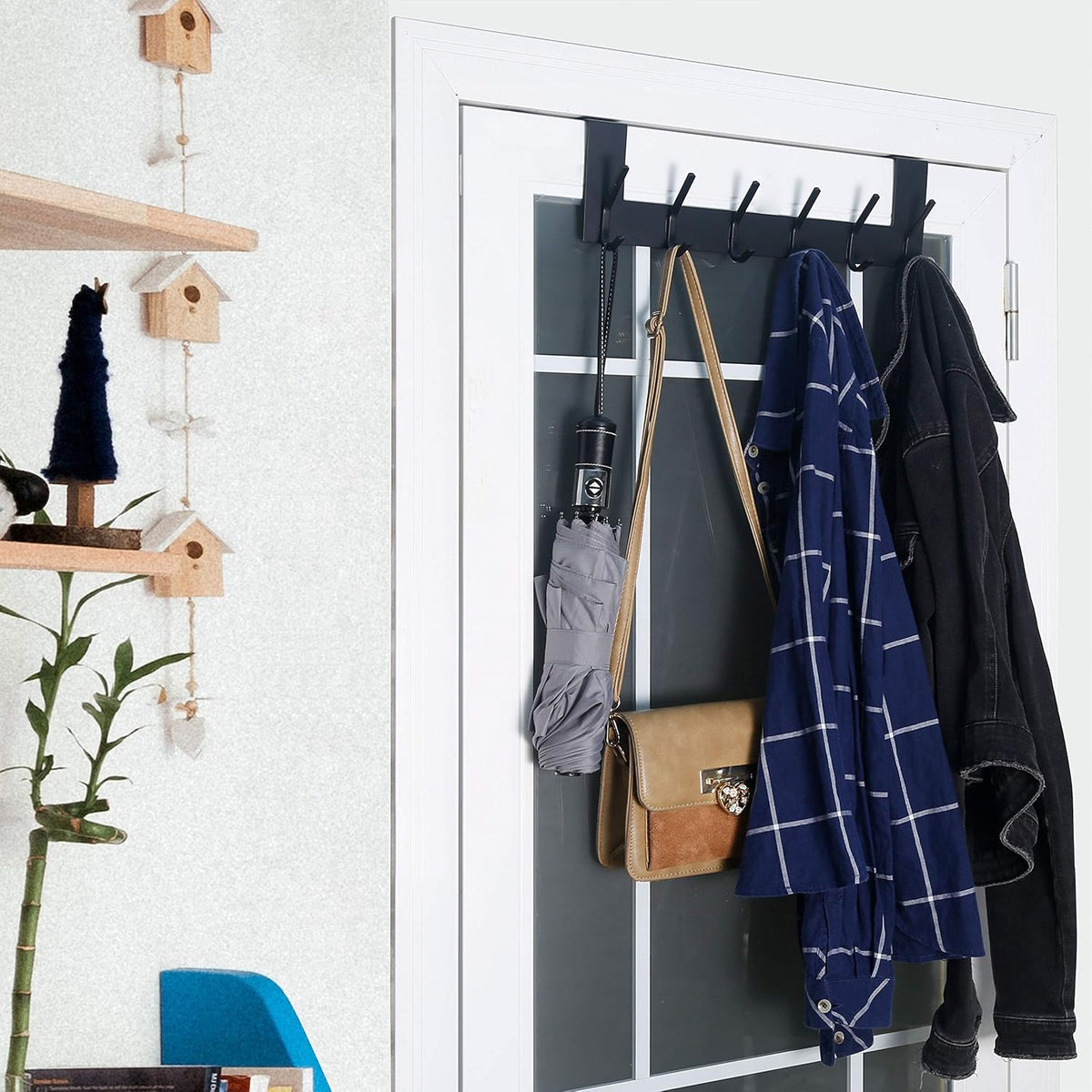 Installed over-the-door rack holding a purse, umbrella and coats in an entryway setting