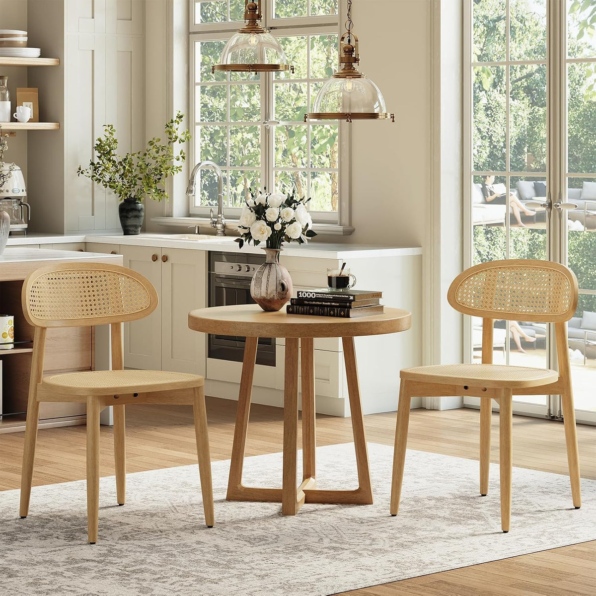 Sunny kitchen vignette with two light natural cane-back chairs flanking a small round table.