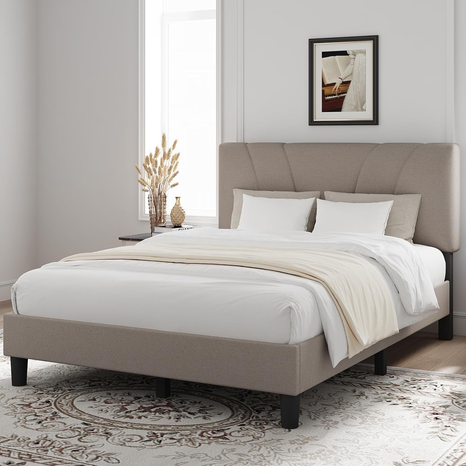 Angled bedroom view of a taupe upholstered platform bed with a fan-pattern headboard.