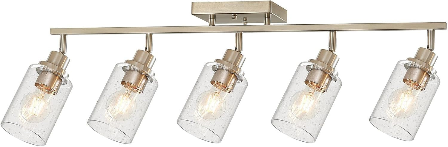 Five-light brushed nickel track light on white background with seeded glass cylinder shades evenly spaced