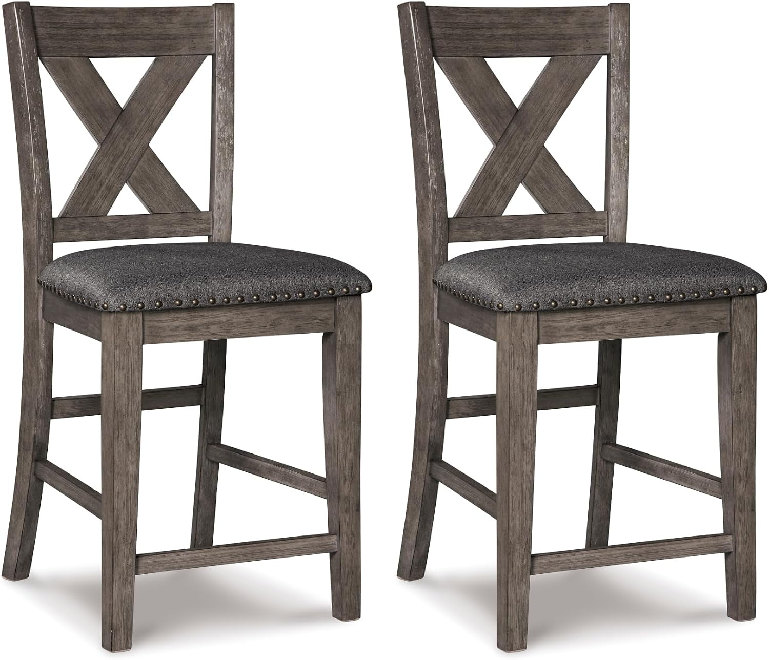 Two counter-height wooden bar stools with X-shaped backs, weathered gray finish and dark upholstered seats with nailhead