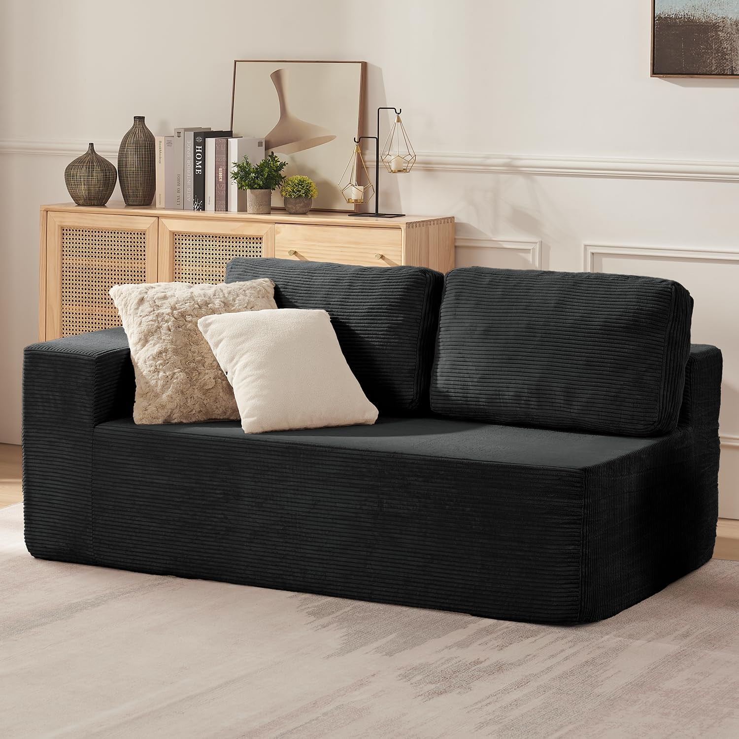 Side view of a two-seat charcoal module with two textured throw pillows against a wood sideboard.