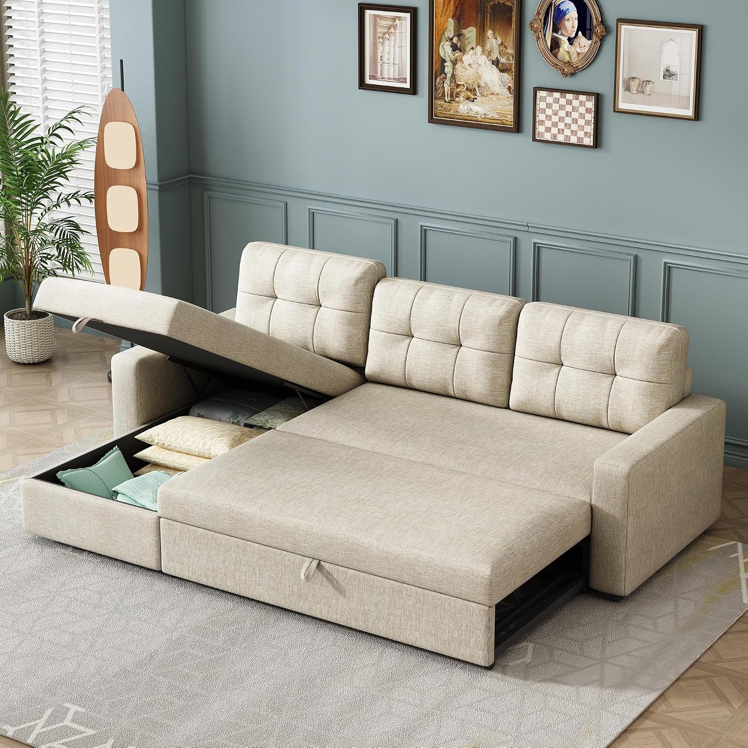 Beige sectional converted to a flat sleeper with one storage compartment open showing folded pillows and blankets.