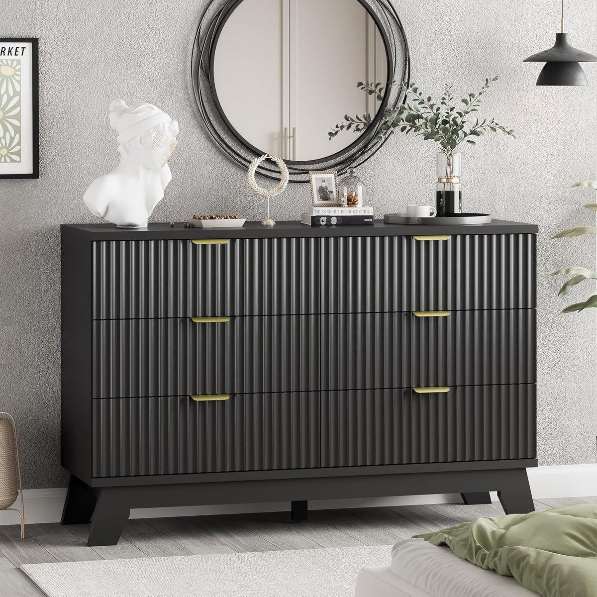 Front view of a black wave-panel dresser with gold pulls under a round mirror and decorative objects.