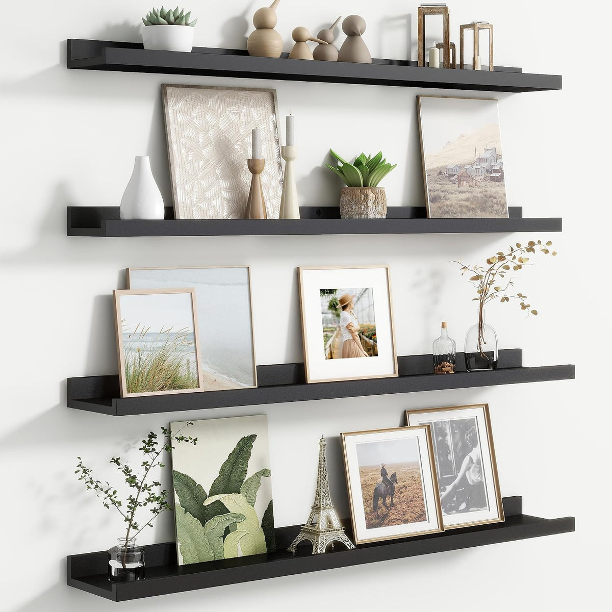 Three black floating picture ledges mounted vertically with framed photos and small decor items.