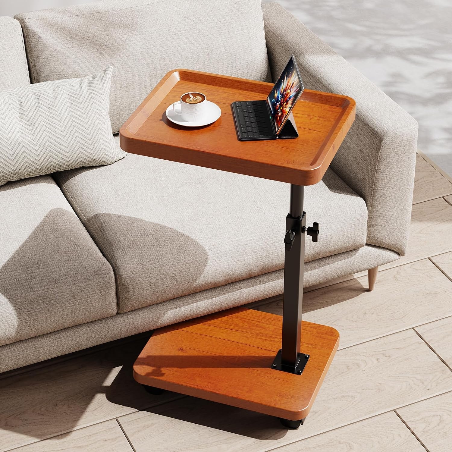 Walnut-finish adjustable C-table placed next to a light sofa with a cup and tablet.