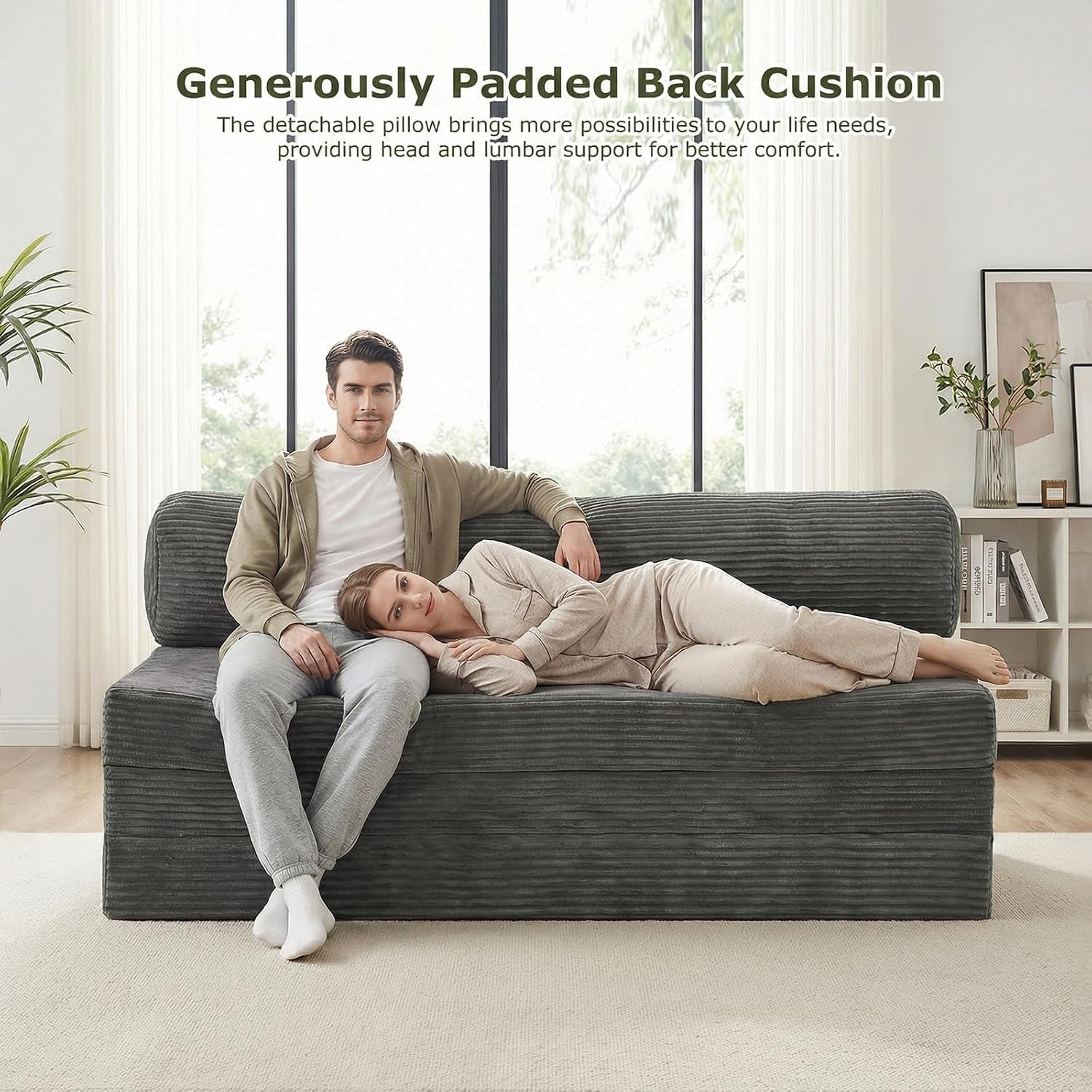 Couple relaxing on a grey corduroy boneless loveseat placed before tall windows in a bright living space