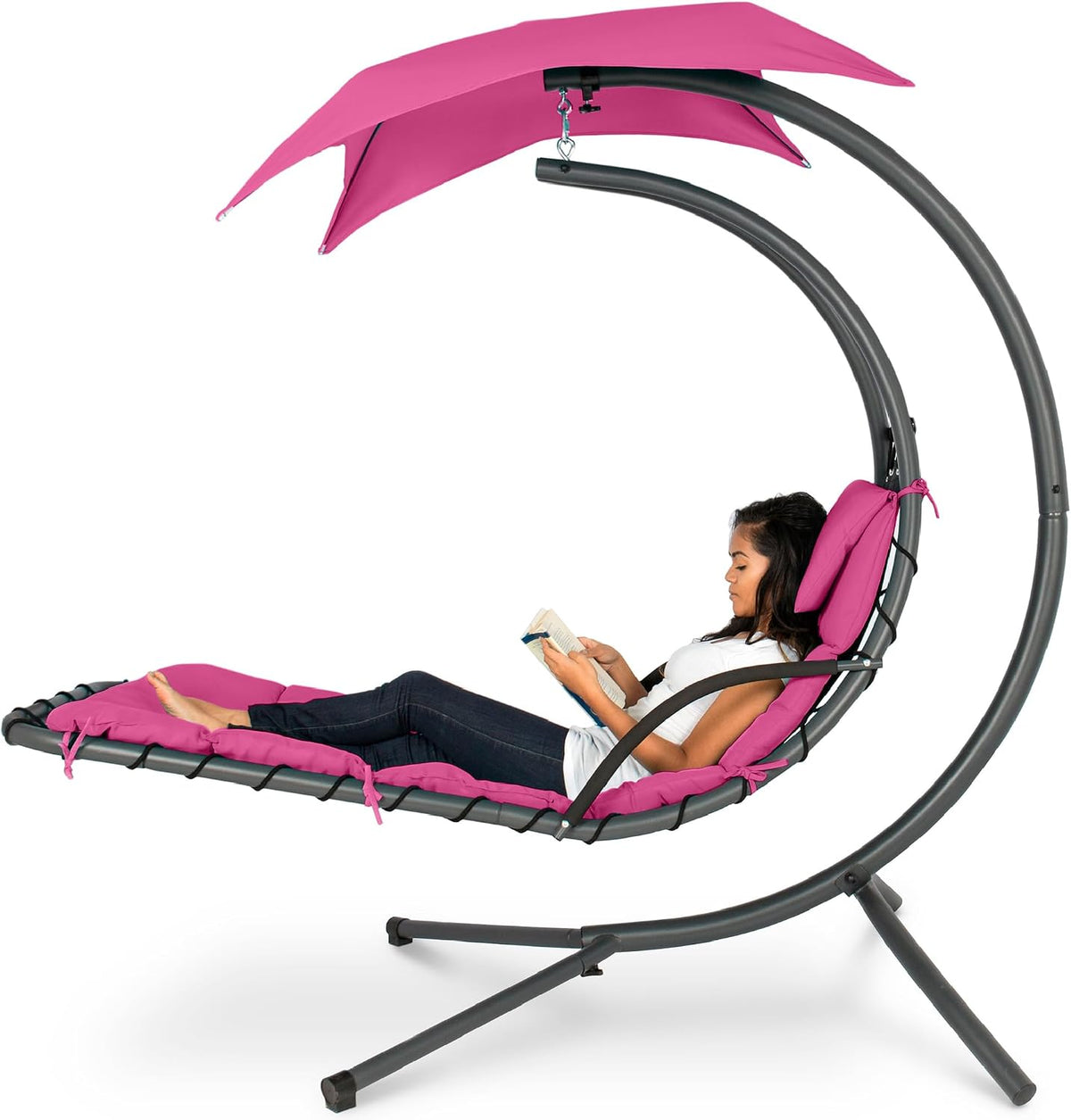 Same curved hanging chaise shown with bright pink cushion and canopy and a woman lounging with a book.