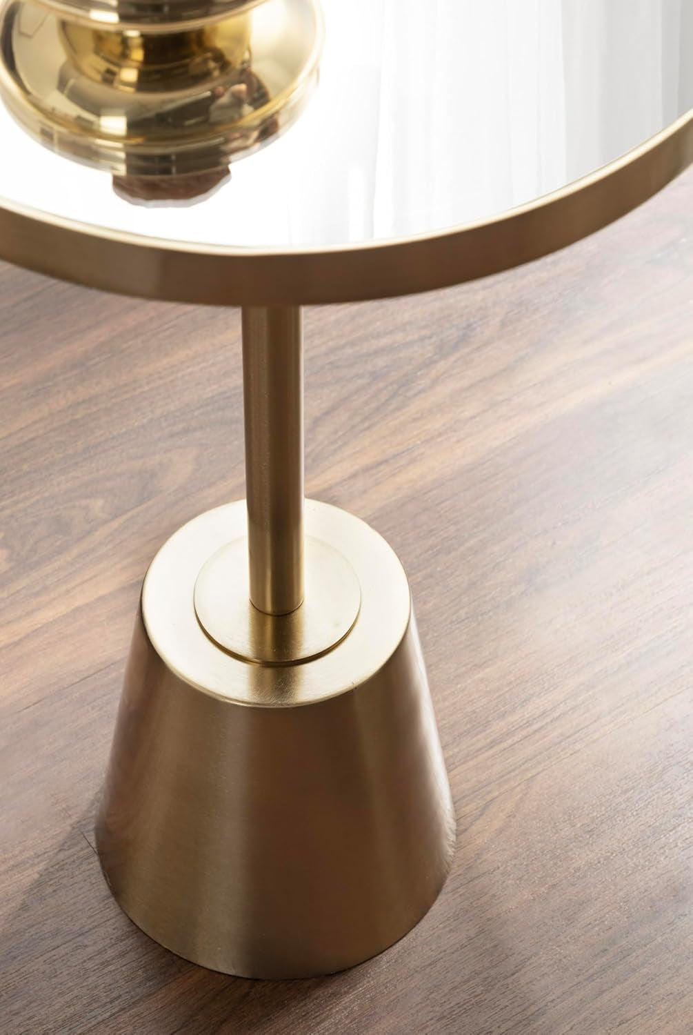 Detail view of the brushed gold metal base and cylindrical stem with the top plate visible