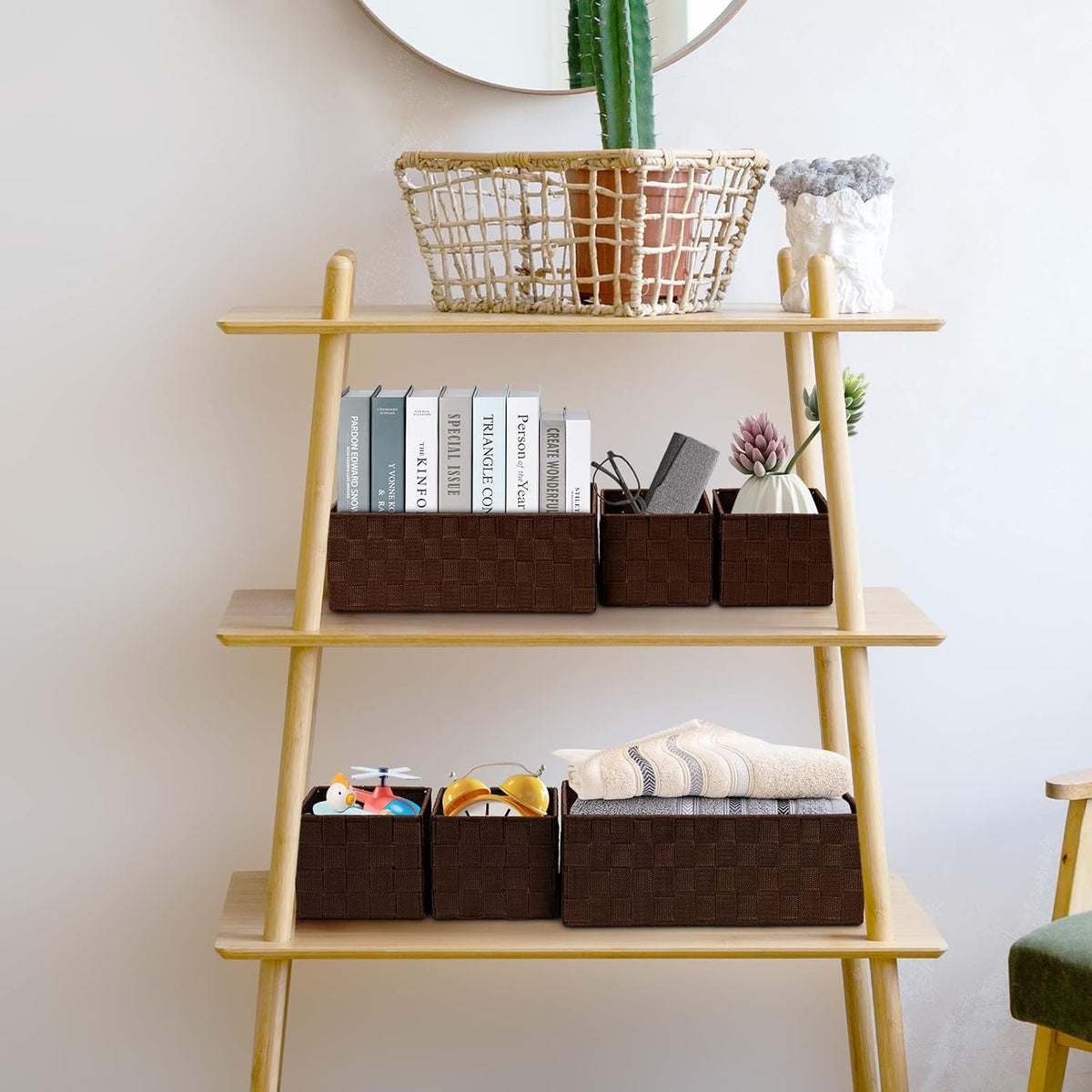 Brown woven baskets of various sizes on a wooden ladder shelf, front view showing organization with books and toys