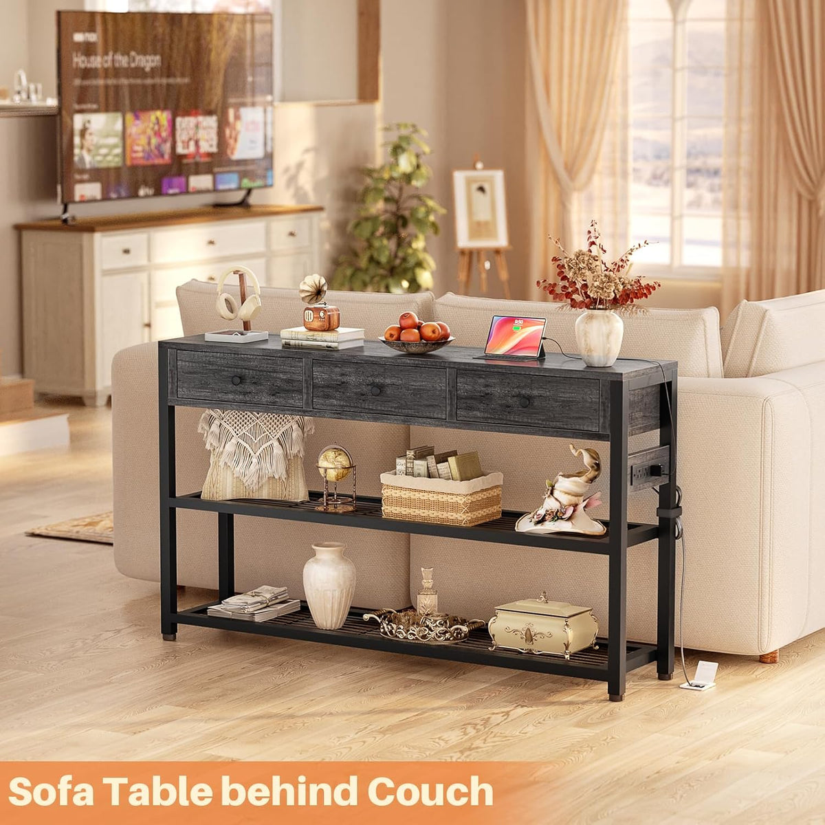 angled view of the console table set behind a beige sofa with a tablet, vase and baskets on its shelves
