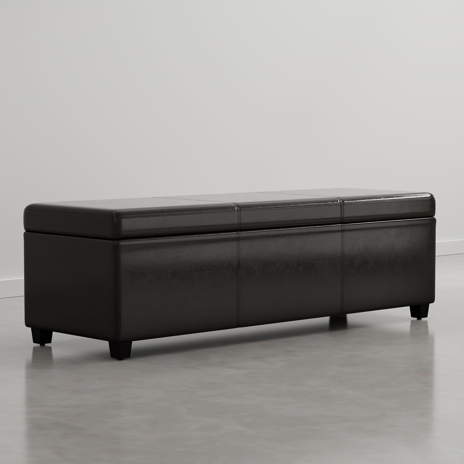 Dark brown rectangular storage ottoman placed on a polished concrete floor against a plain wall.