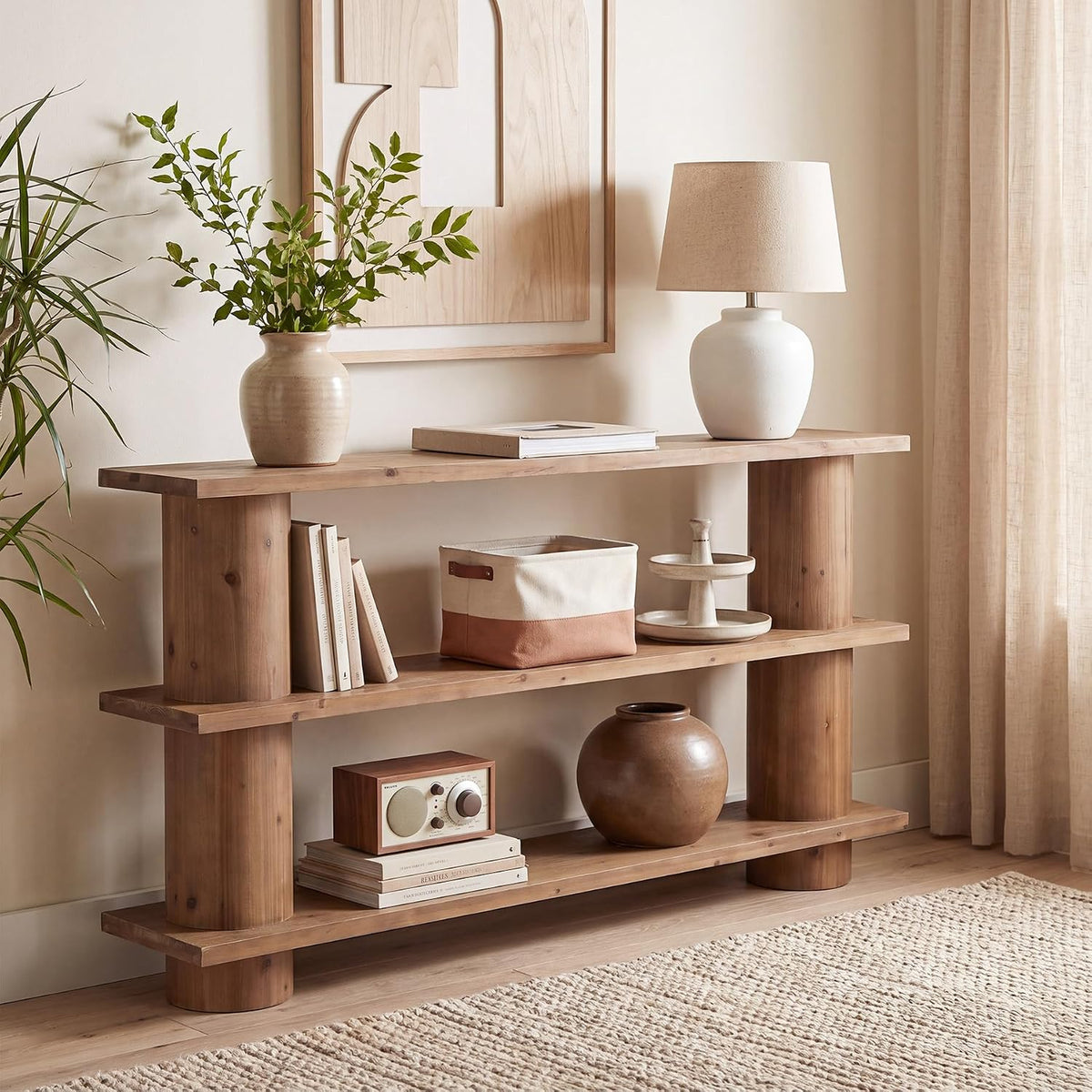 Side view of the three-tier console table styled with a lamp and potted plant in a neutral living room