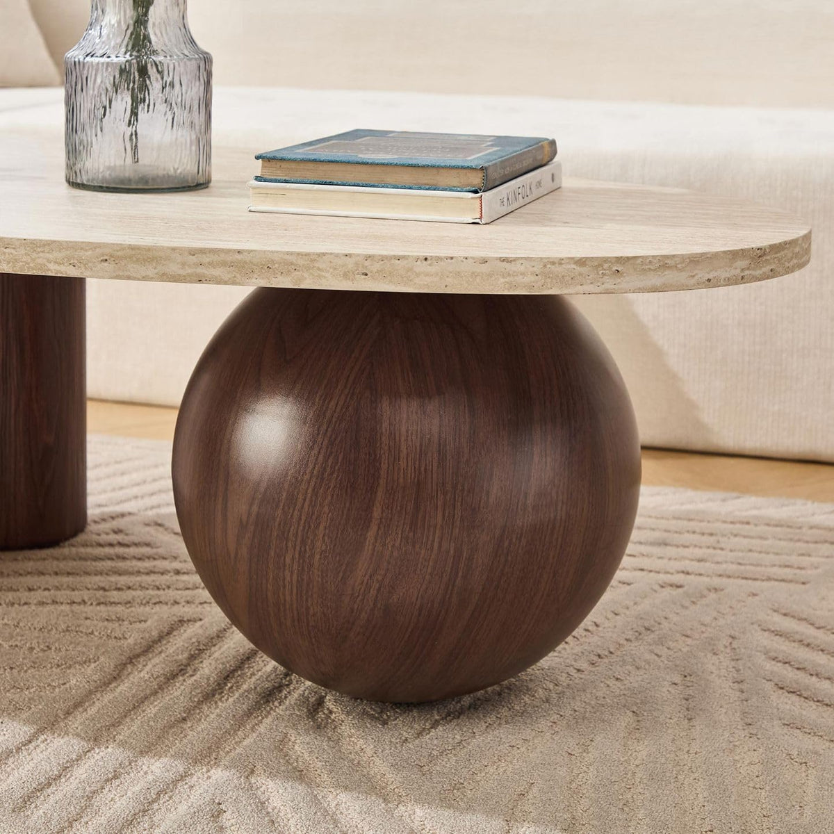Close-up of travertine-style tabletop edge and walnut-finish spherical leg showing wood grain