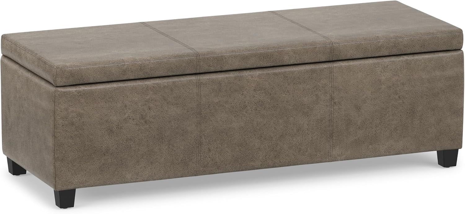 Warm taupe rectangular storage ottoman with textured upholstery, stitched top panels, and short black legs.
