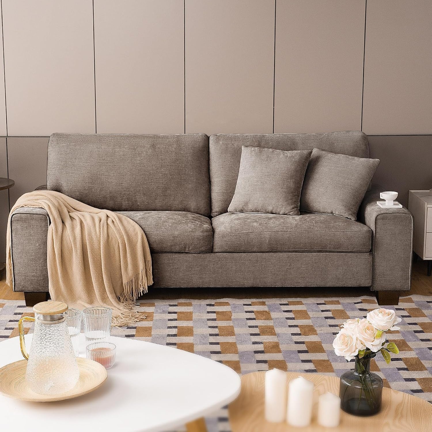 Front view of a light taupe chenille loveseat with two cushions, small side table and decorative vase nearby.