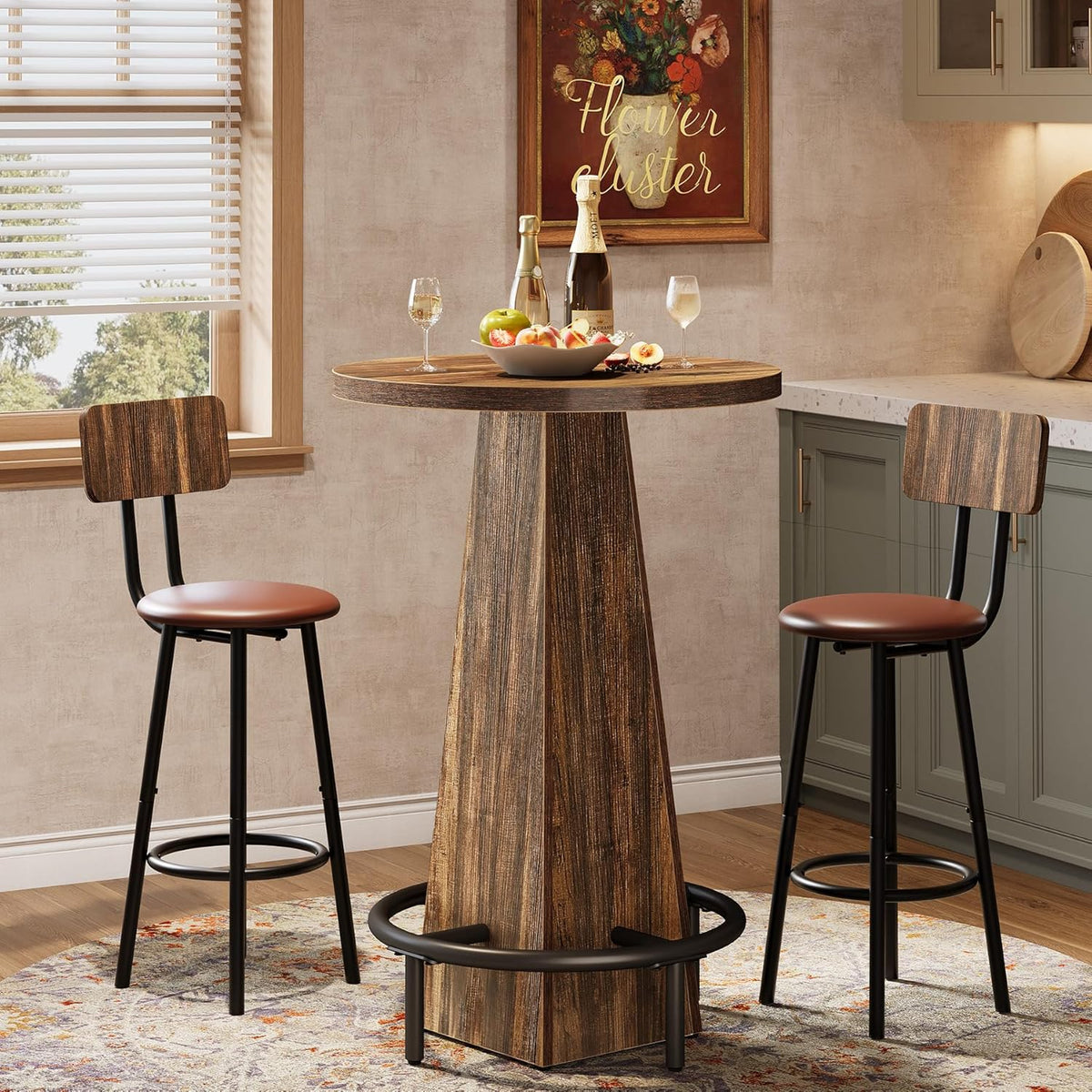 Round bar table in rustic brown with metal footrest surrounded by two wood-back bar stools in a kitchen