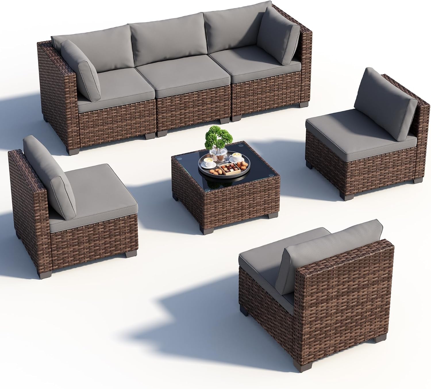 Isolated product view of the seven-piece rattan sofa set with grey cushions and square glass coffee table on white