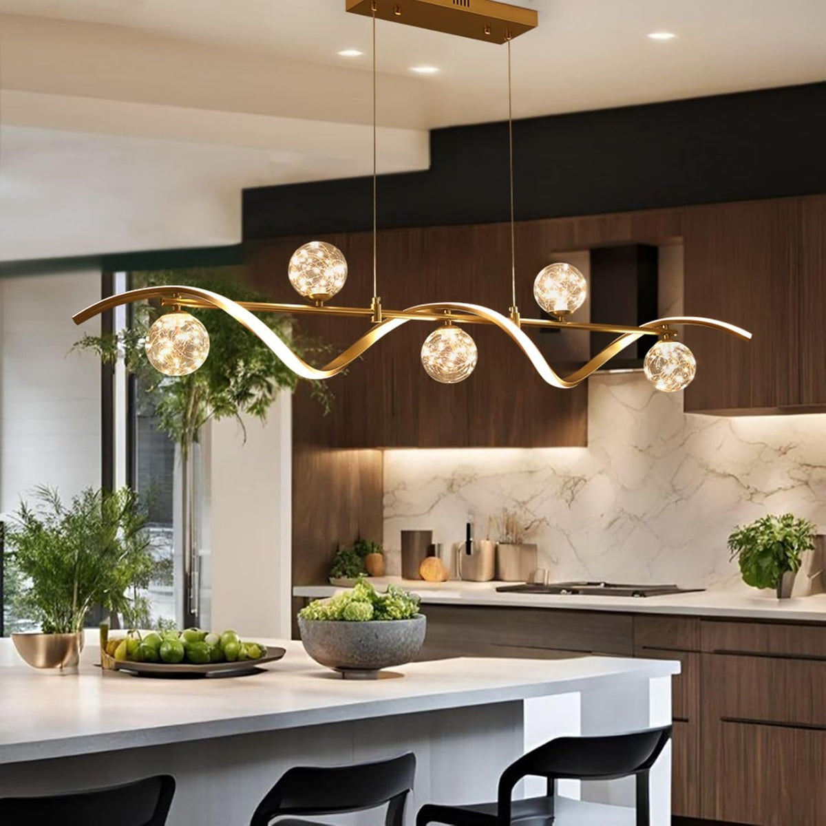 Side angle of gold 6-light chandelier suspended over a kitchen island with visible wires and globe shades
