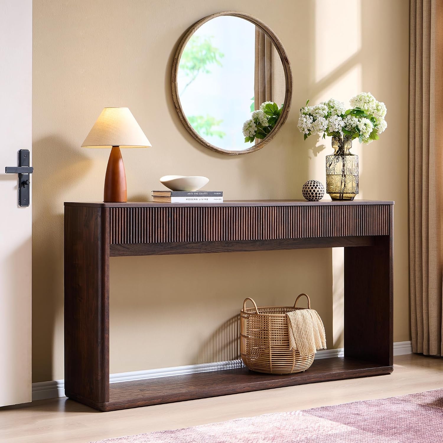 Warm brown console shown from a slight side angle highlighting rounded outer leg and woven basket on the bottom shelf.