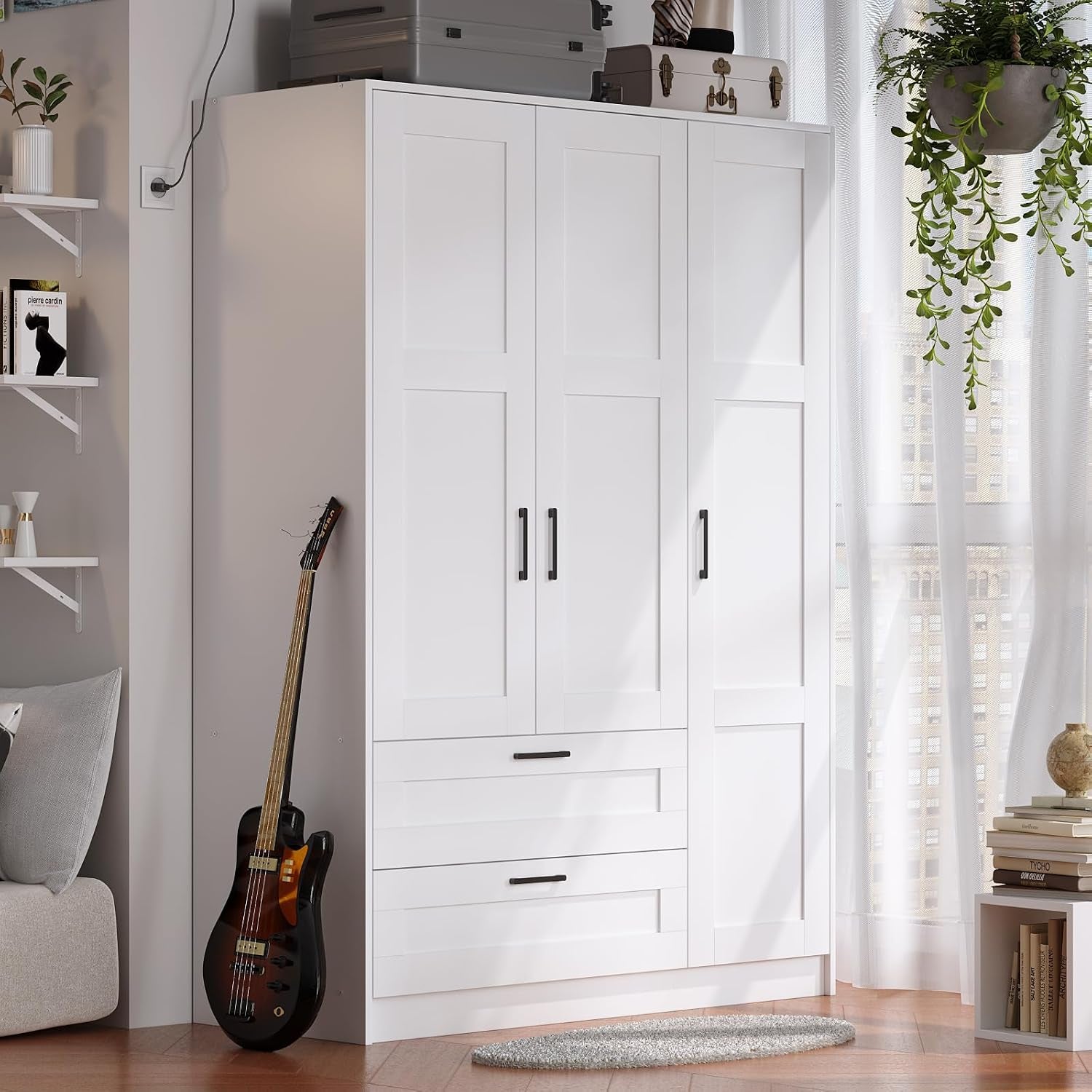 White freestanding 3-door wardrobe with two drawers, angled front view in a styled living area