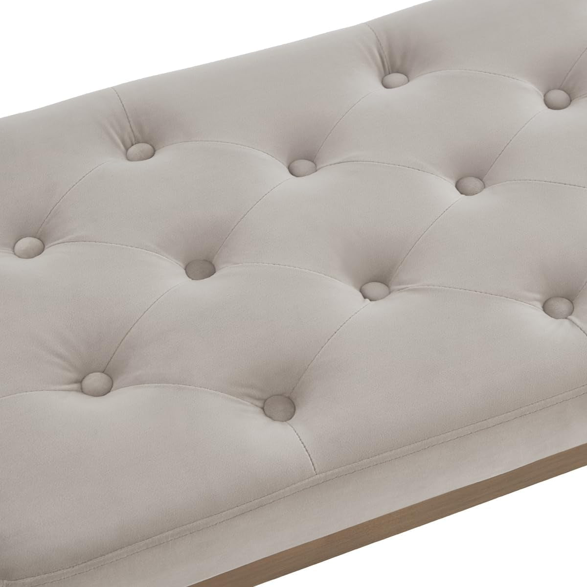 Close-up of tufted velvet seat showing button tufts and stitched seams on light upholstery
