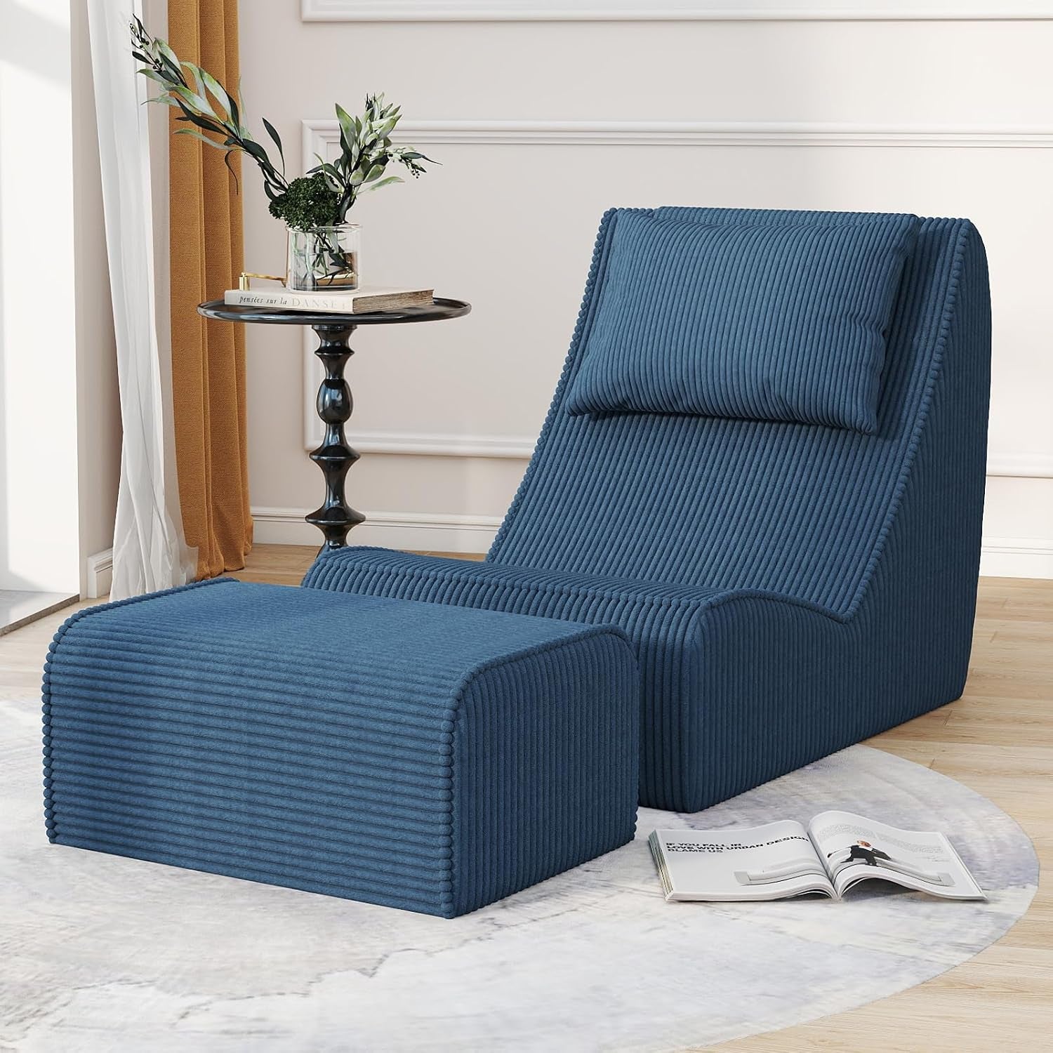 Blue ribbed chaise lounge and ottoman in three-quarter view beside a black round side table and open magazine.
