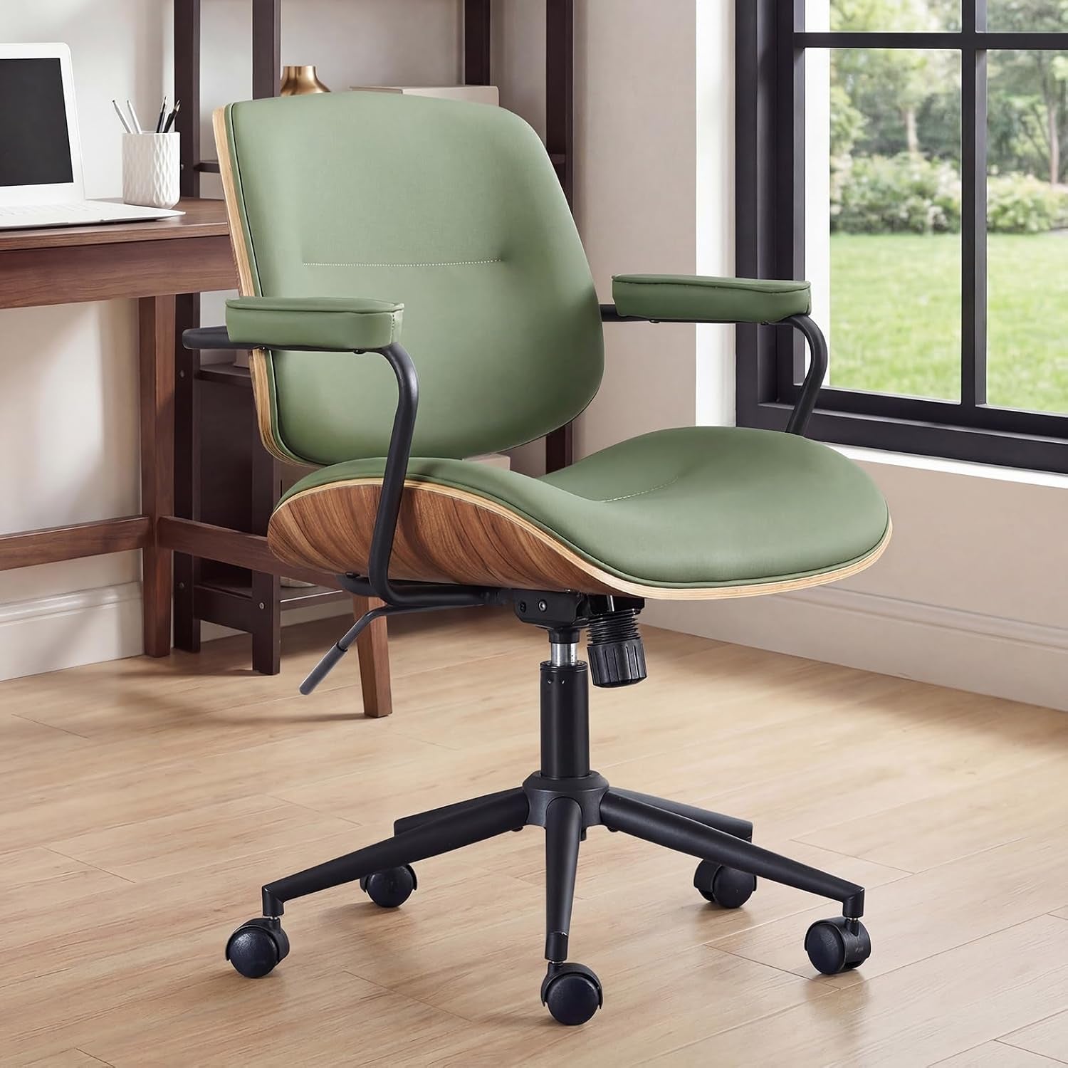 Green office chair beside a desk in a bright home office by a window