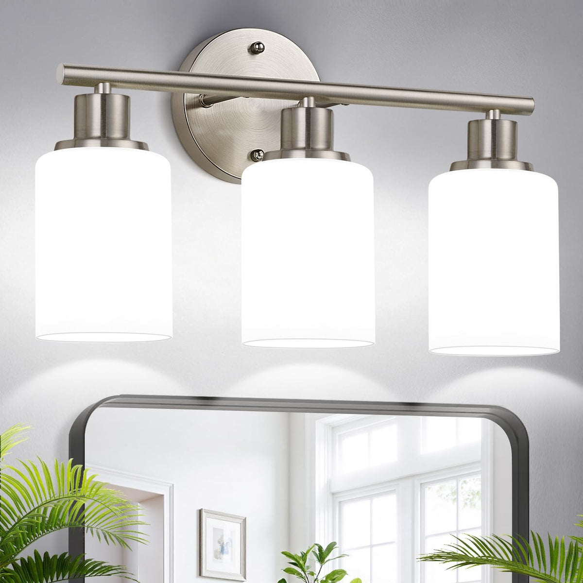 Three-light brushed nickel vanity light with white cylindrical shades shown above a mirror.