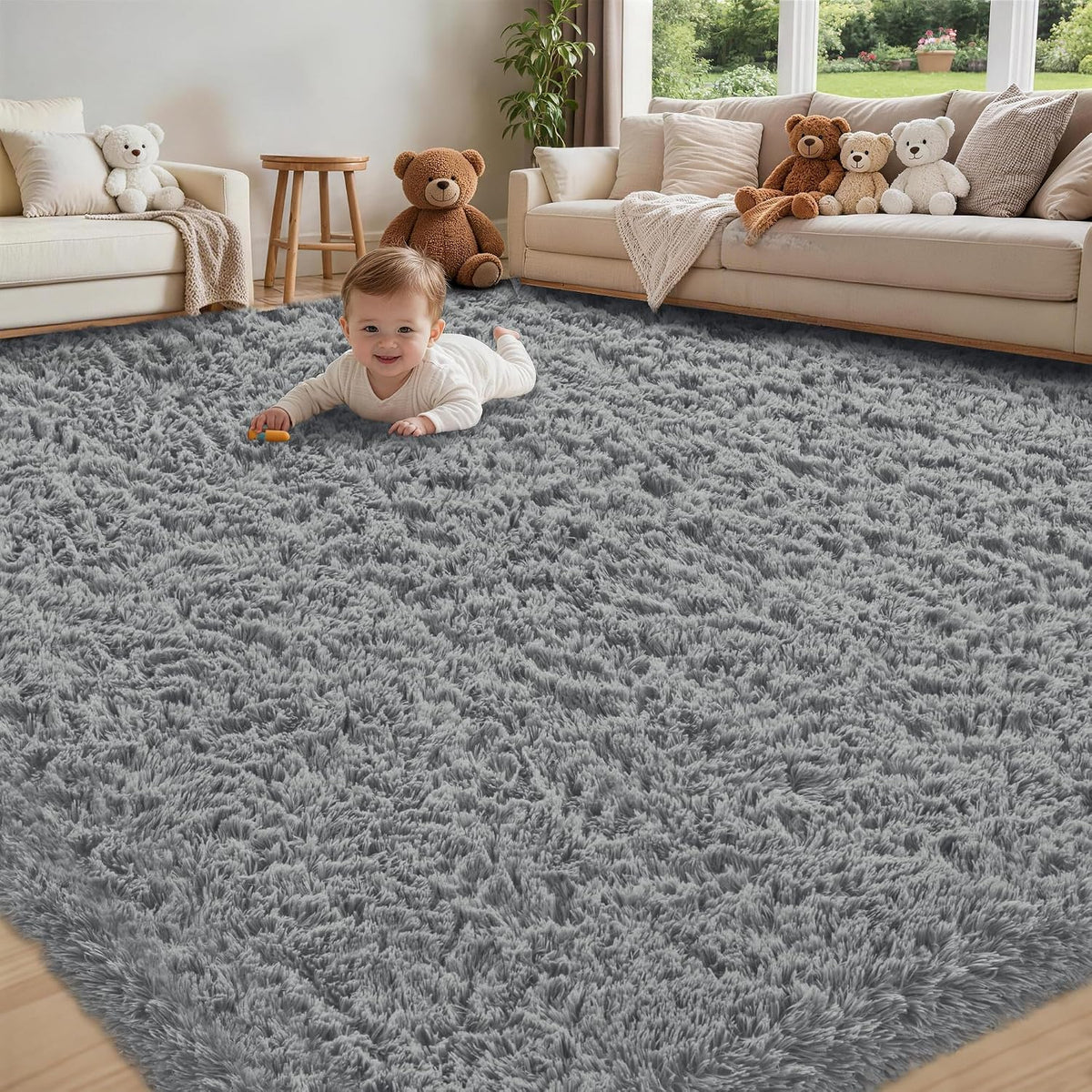 Baby lying and smiling on a soft gray shag rug in a family room with teddy bears on the sofa.
