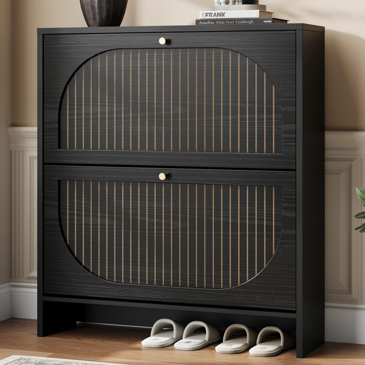 Front view of a slim black shoe cabinet with arched rattan-style panels and two flip drawers.