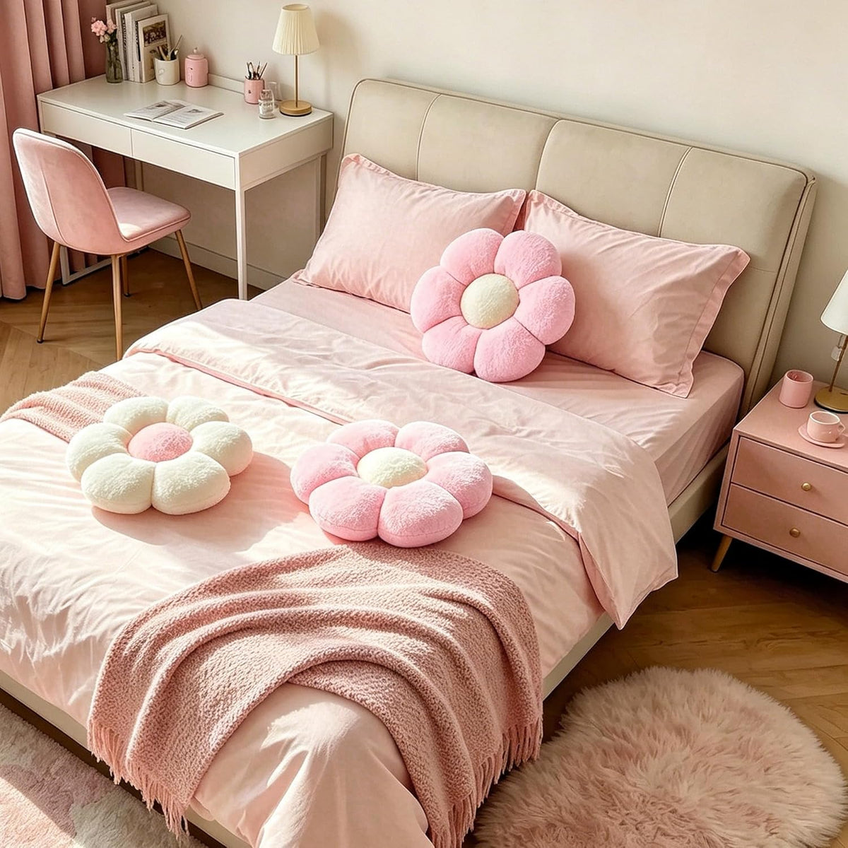 Pink and white daisy pillows styled on a pink bedspread and against a beige headboard in a bedroom setting