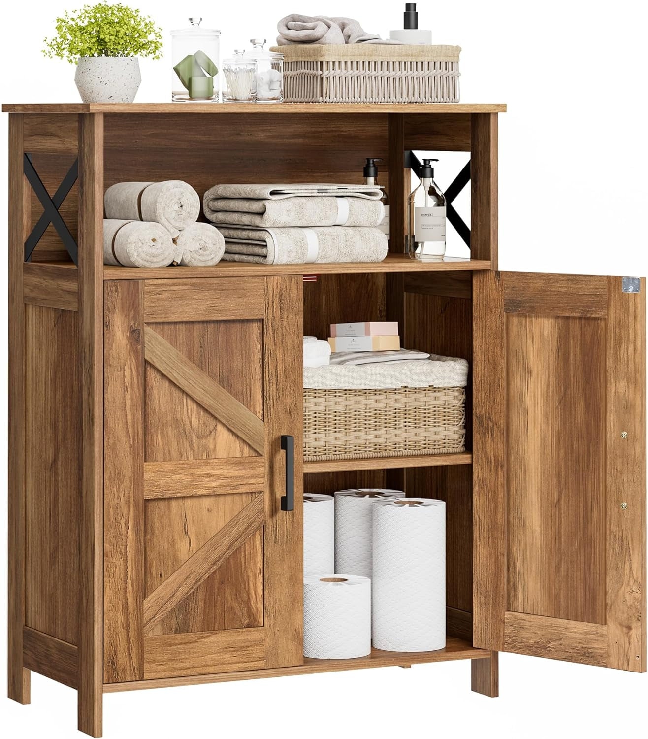 Wood-finish freestanding cabinet with barn-style door panels, one door open revealing basket and toilet paper rolls