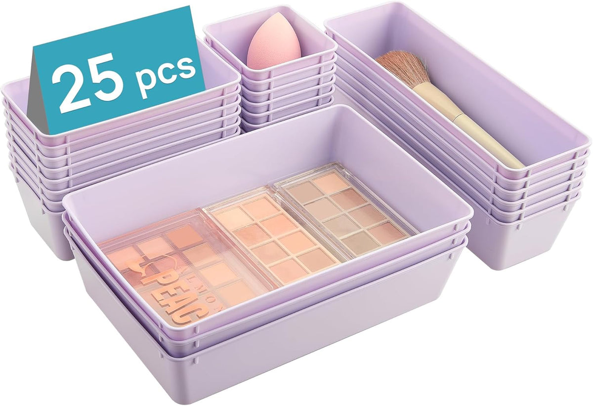 Stacked lavender plastic organizer trays shown at an angle with makeup palettes, brush and sponge inside