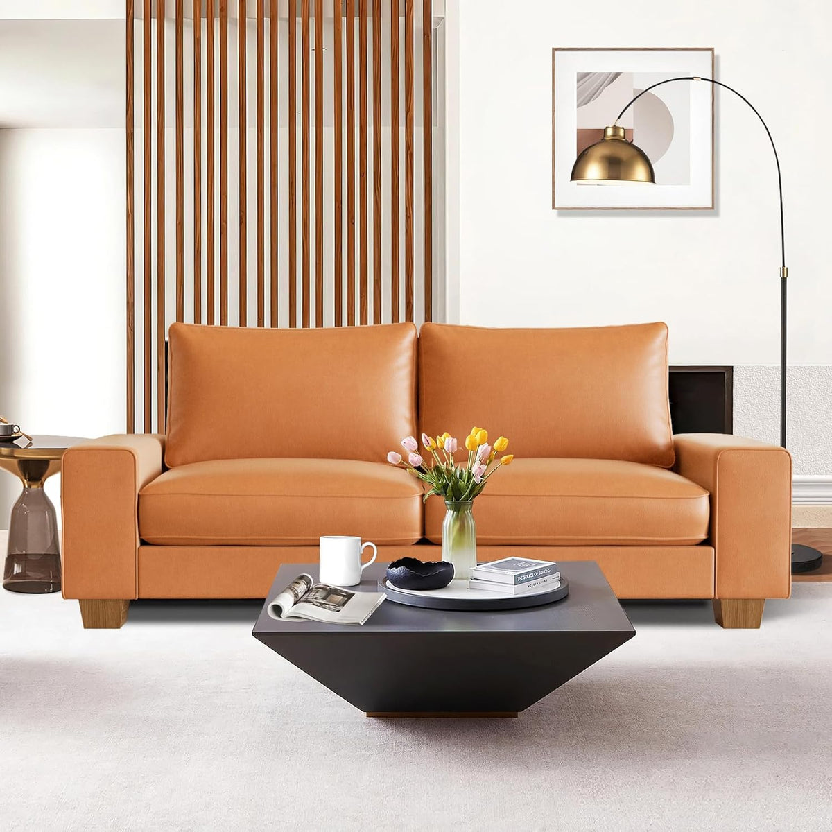 Brown faux leather loveseat centered in a modern living room with a geometric coffee table front view.