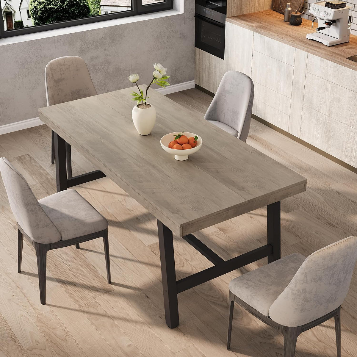 Rectangular extendable table in a light natural wood finish with black metal legs and upholstered chairs.