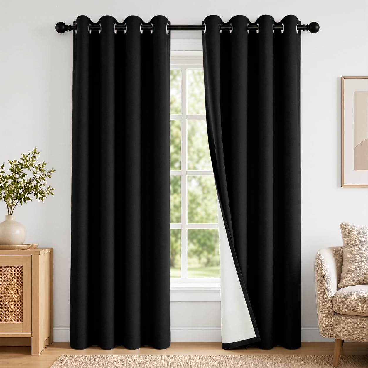 Black grommet-top curtains hung over a window with one panel slightly pulled to show white backing.