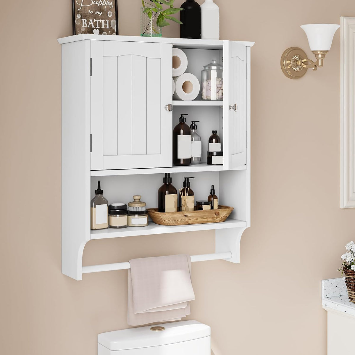 White wall-mounted bathroom cabinet with two doors, open shelf and towel bar over a toilet.