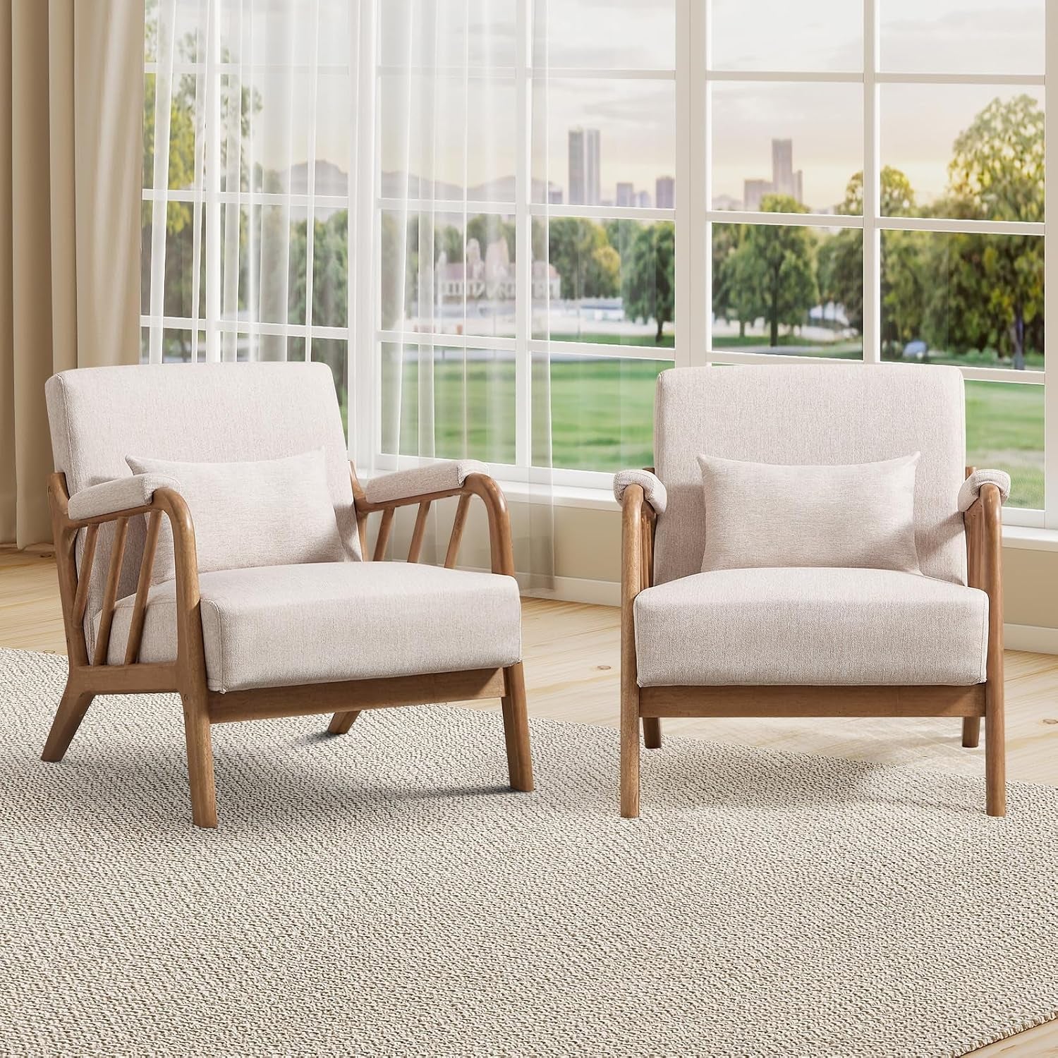 Two light beige fabric accent chairs with wooden frames placed before large windows on a woven rug.