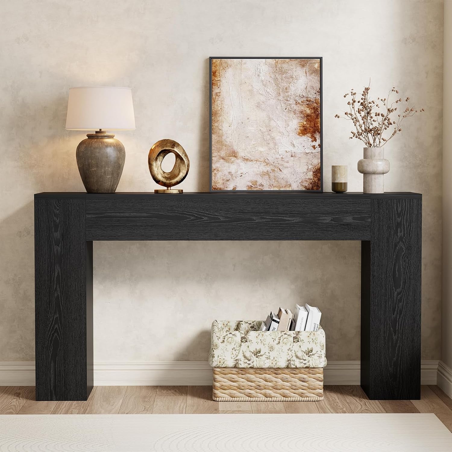 Cropped front shot of a deep black console table highlighting straight block legs and tabletop decor.