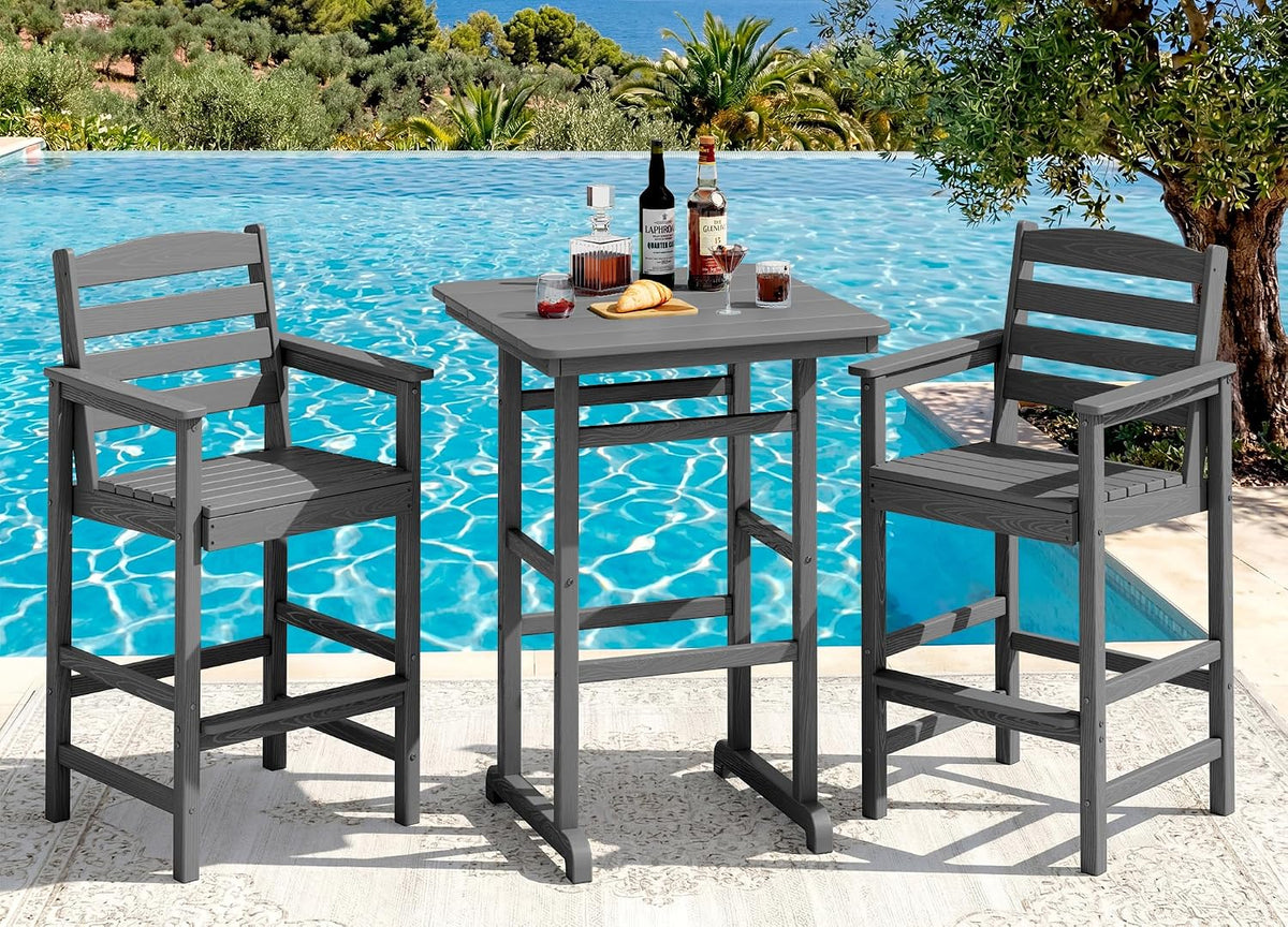 Same three-piece bar set in medium gray shown by a pool, two chairs and a square table with glasses and bottles.