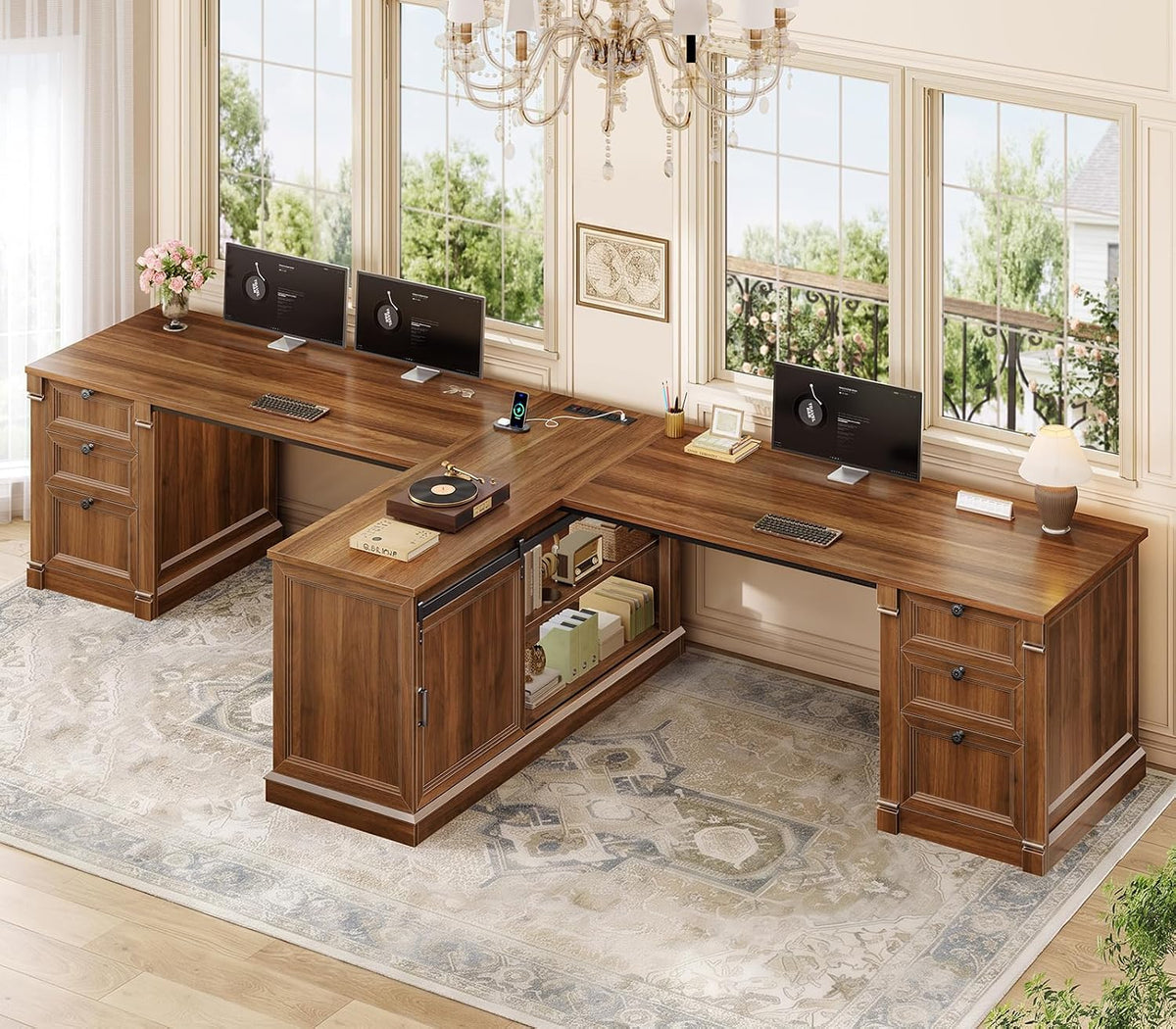 Wide angled view of the wood L-shaped desk showing dual work surfaces, a sliding-door cabinet and charging area.