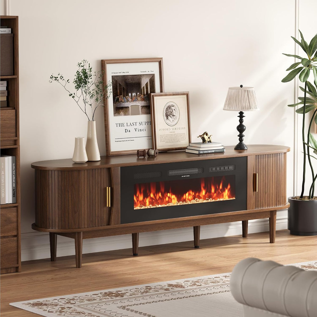 Side view of walnut console showing curved tambour door, gold handle and decorative frames on top
