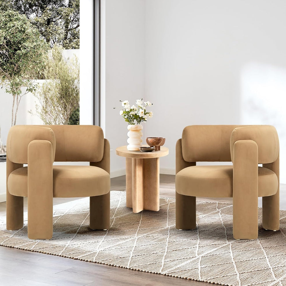 Pair of khaki velvet barrel accent chairs facing front with a small round wooden table between them in a living room