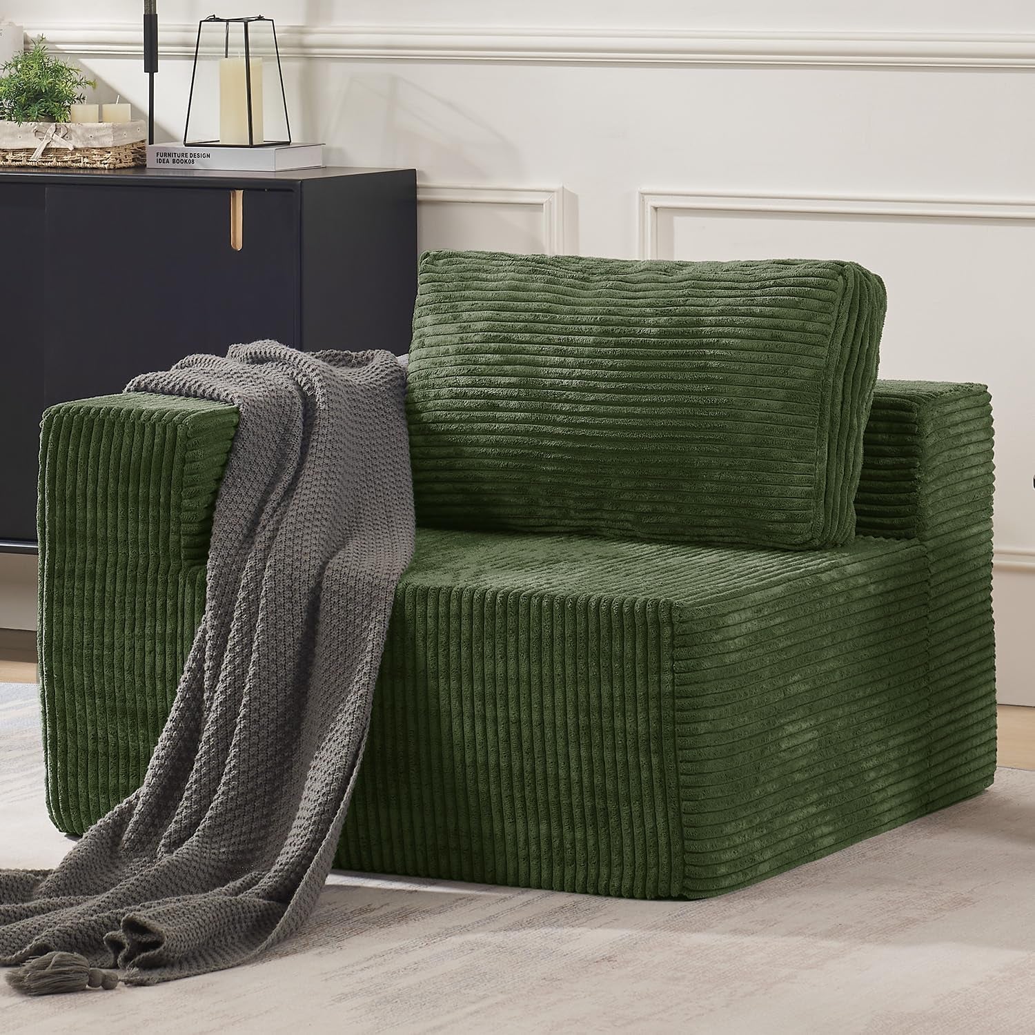 Green corduroy-textured modular armchair with a gray knitted throw cascading to the floor.