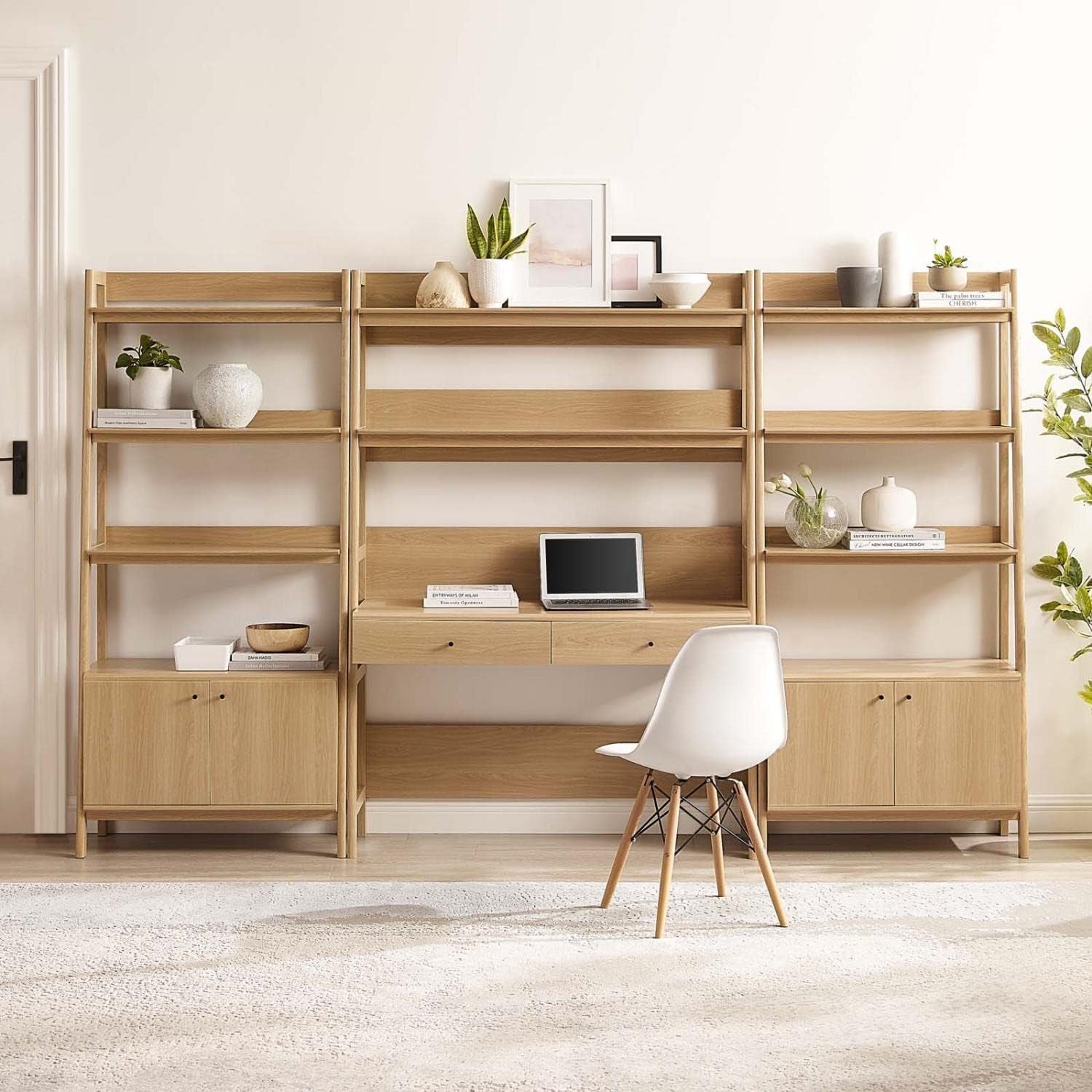 Oak finish set styled in a bright room with a white chair, showing desk workspace and decorative items on shelves