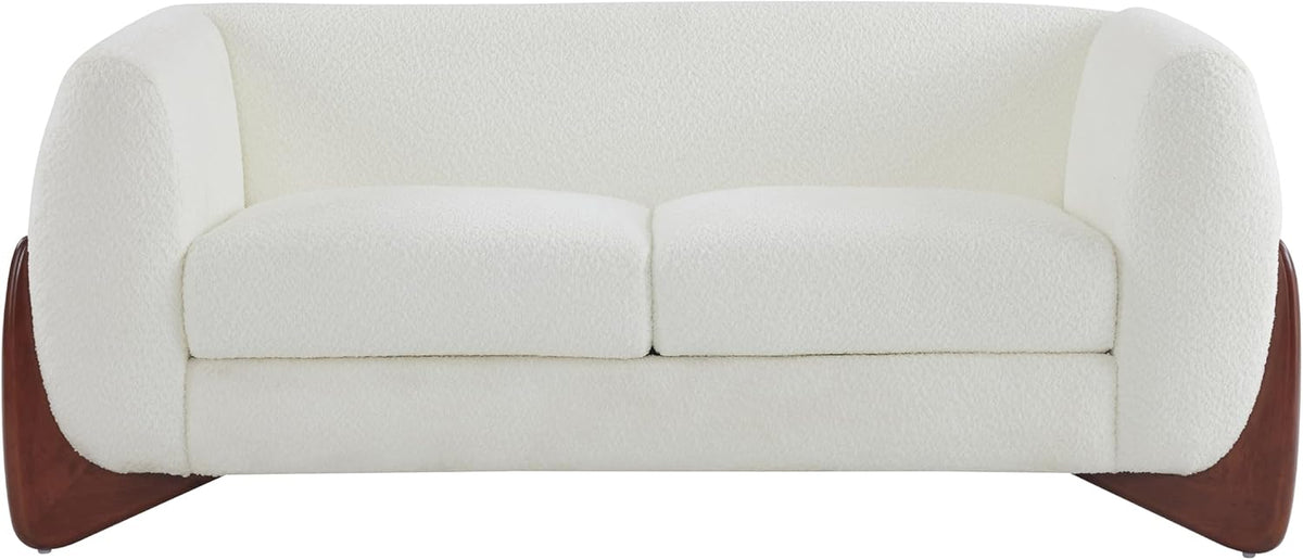 Cropped frontal image of the cream bouclé sofa focusing on seat cushions and the sculpted wooden base at each corner.
