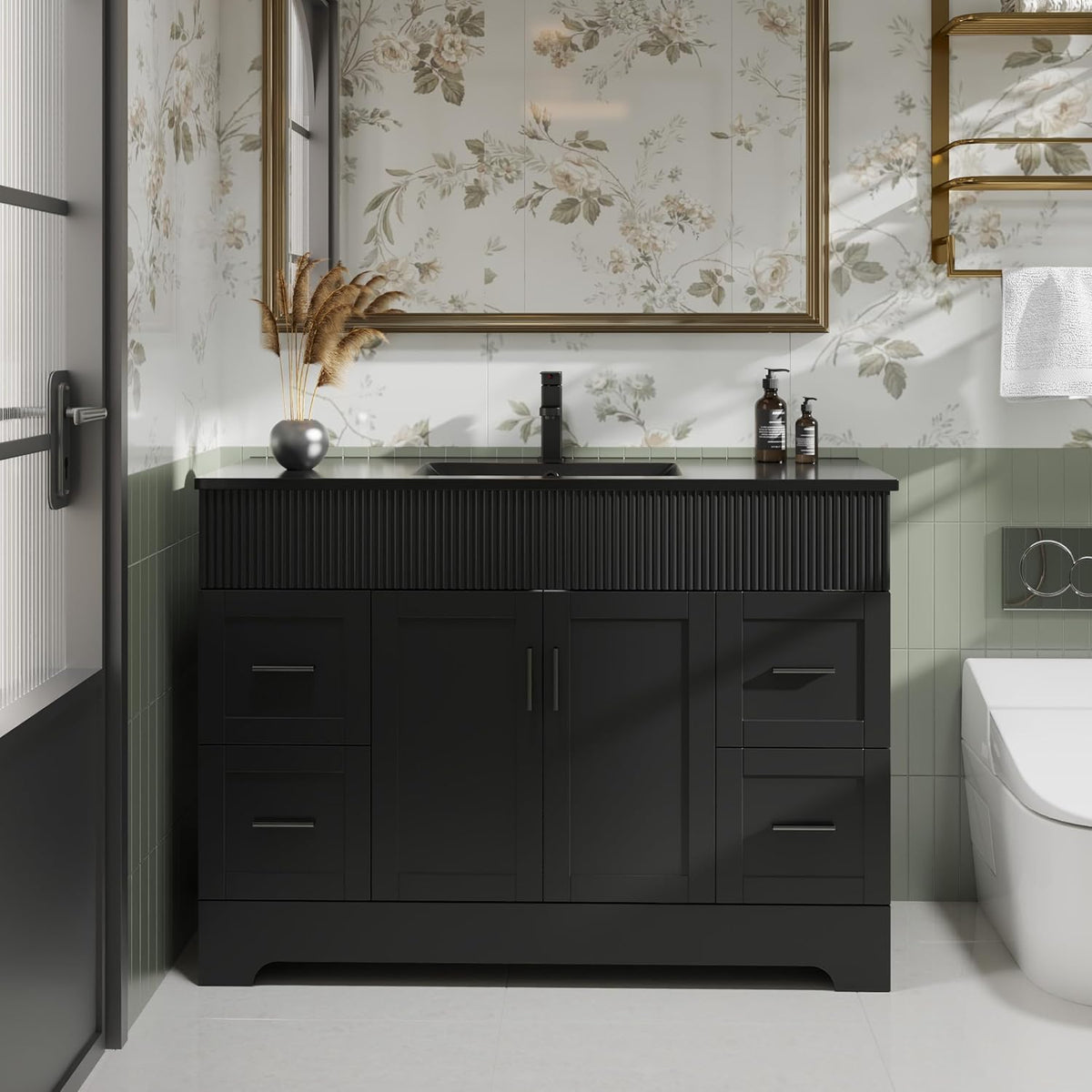 Close frontal view of a black vanity showing ribbed upper panel, drawers and cabinet doors