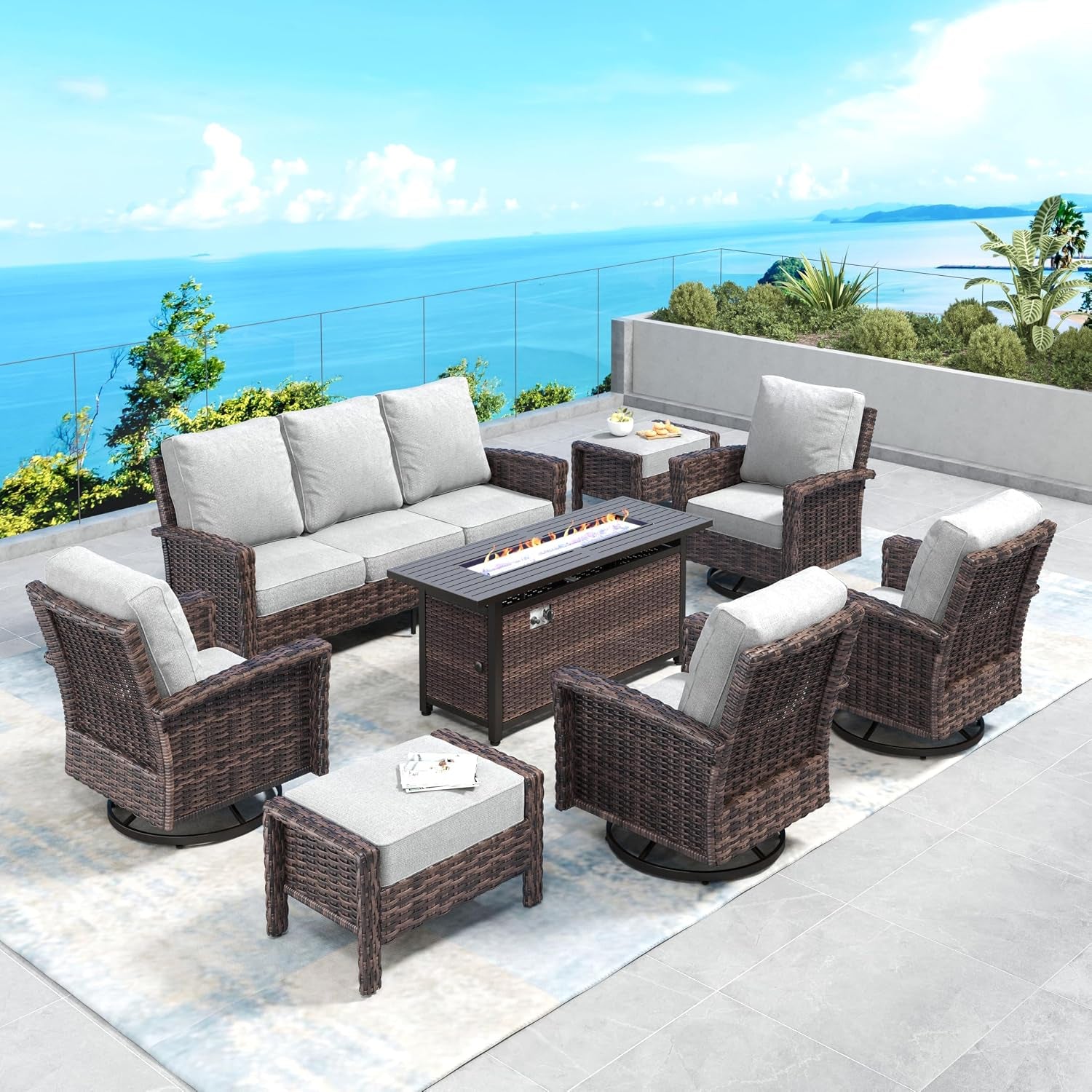 Outdoor seating set circling a rectangular fire table, wicker chairs and a sofa with light gray cushions