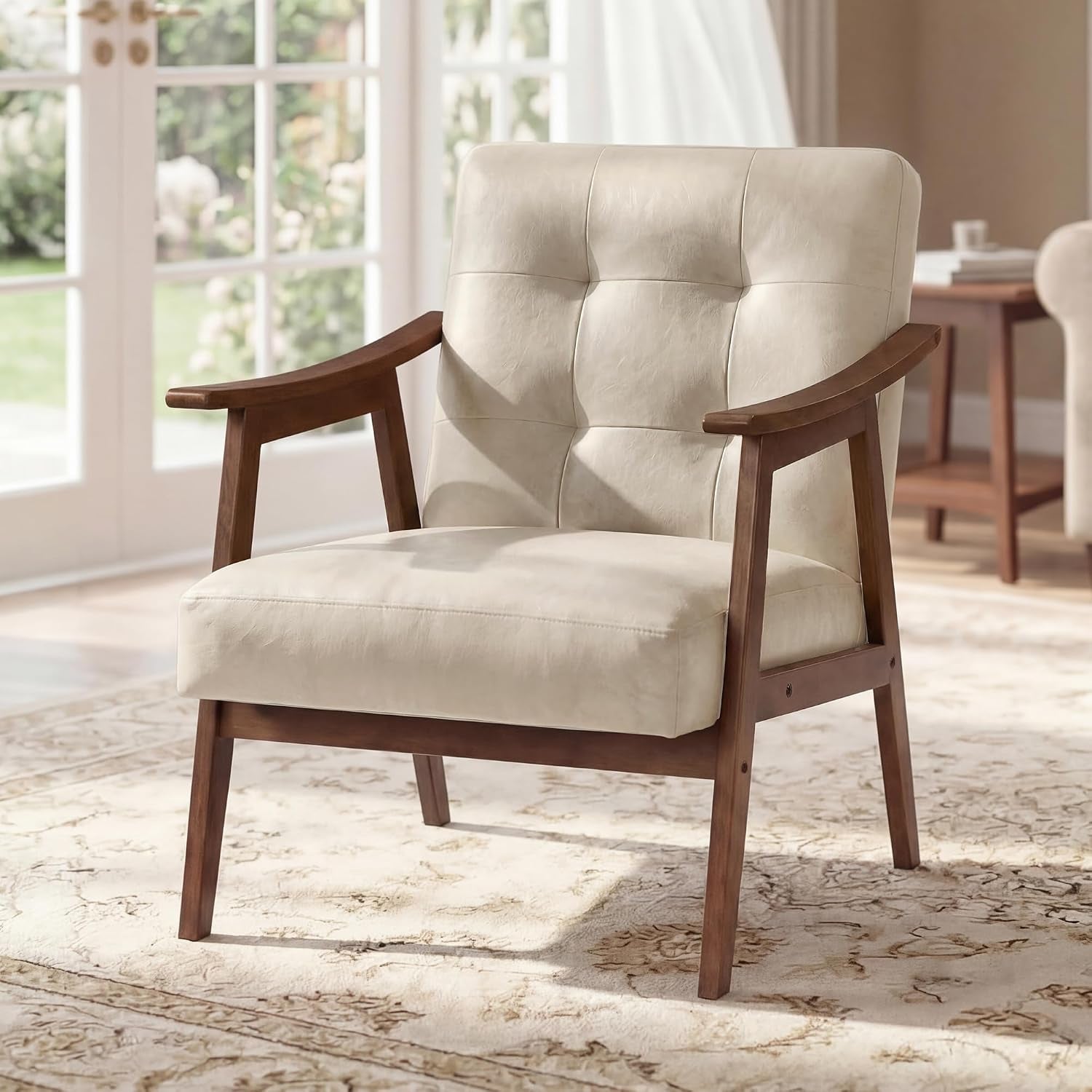 Front three-quarter view of a beige tufted armchair with wooden arms and legs in a bright living room.